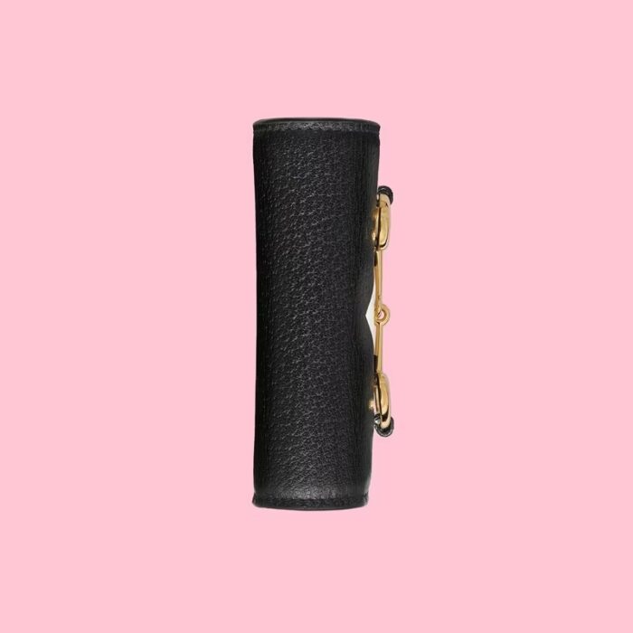 this card case features the Trefoil print. Emblematic House’s motifs mix with those of the historic sportswear brand adidas. The collection sees both heritages encoded in a trio of lines