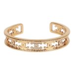This cuff bracelet is in?gold tone metal with clear crystal CC logos.