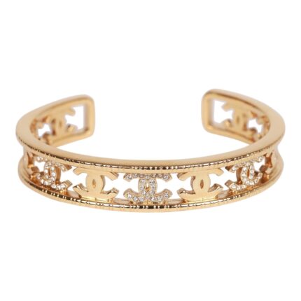 This cuff bracelet is in?gold tone metal with clear crystal CC logos.