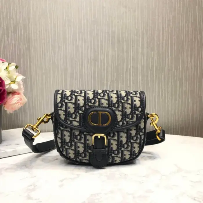 including a back pocket and an interior flat pocket. Its adjustable and removable sliding leather shoulder strap features a ‘Christian Dior’ military-inspired buckle