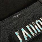 with several pockets including one with a flap. Closing by a magnetic flap. It is signed "Christian Dior Paris". The metal plate on the front of the bag is the signature of the collection. It has never been used. It's made in Italy