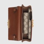 the style is crafted from the House's monogram canvas and accentuated by a black leather top. Adding to the styles contrasting elements