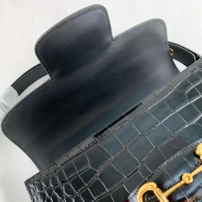 allowing you to adjust the drop length from 9.8 inches to 17.7 inches according to your preference. The flap closure adds an extra layer of security to keep your essentials safe.Experience the allure of the Gucci 1955 Horsebit collection with this remarkable crocodile shoulder bag. Elevate your style and make a bold fashion statement with this iconic piece from Gucci.