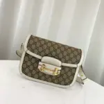 which is made with low environmental impact. The bag is accented with brown leather trim and gold-toned hardware.Inside