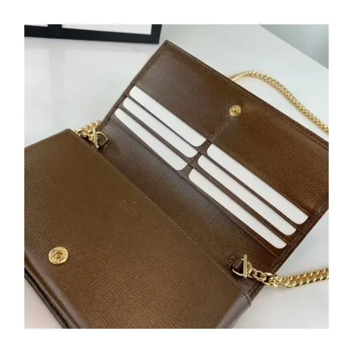 reminiscent of the horsebit found in Gucci handbags.The wallet is adorned with elegant black and white leather details