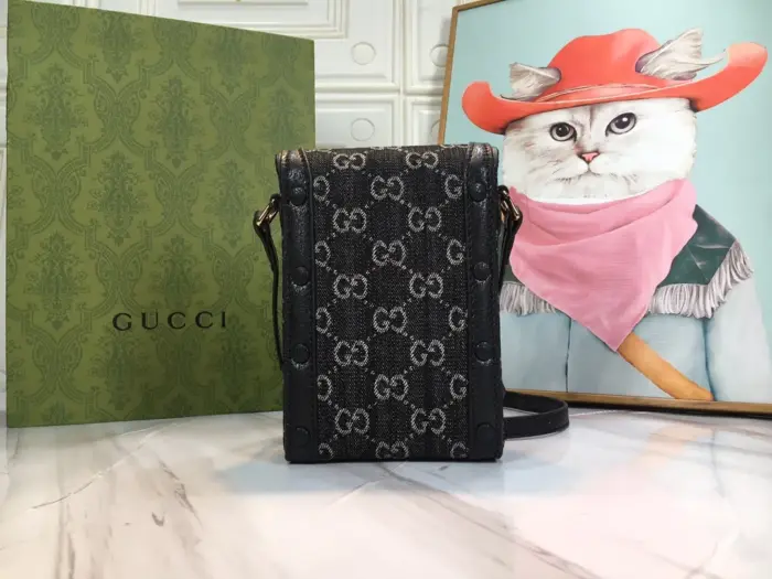 highlighting its connection to Gucci’s rich history. The bag is finished with a sleek black leather trim and signature gold-toned hardware.Made from black and ivory GG denim jacquard