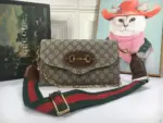 The Gucci Double G Horsebit 1955 Small Bag in beige is a stylish and versatile accessory. Crafted from beige and ebony GG Supreme canvas with brown leather trim
