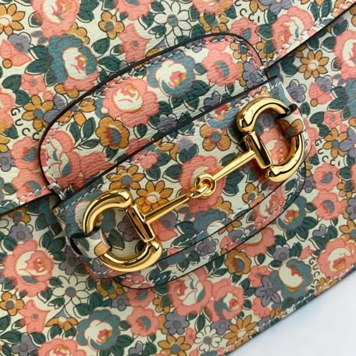 providing ample space for your belongings.The bag showcases a beautiful light pink and light blue floral print by Liberty London on ivory leather