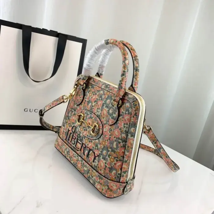 available in a size of 9.8 W x 9.5 H x 3.5 D (25 x 24 x 9 cm). This exquisite bag features a delicate light pink and light blue floral print by Liberty London on ivory leather