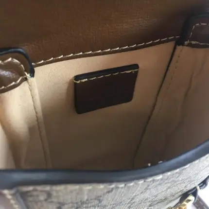 this mini bag embodies the timeless charm of the House. The brown leather trim and gold-toned hardware enhance its luxurious appeal.Designed with practicality in mind