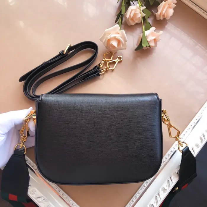 ensuring that your belongings are protected and secure. The black leather mini bag is enriched with a green and red Web