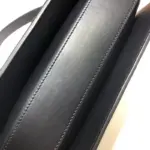 each bag comes with a small pouch containing two button covers that can be used to conceal the studs when the shoulder strap is lengthened. The bag’s interior boasts three gussets