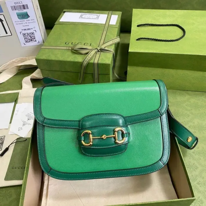 featuring the iconic Horsebit hardware in a vibrant gold tone. The bag is accentuated with luxurious emerald green leather trim