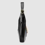 crafted in black leather with an additional detachable shoulder strap. The second shoulder strap can be fastened to the handbag with a buckle