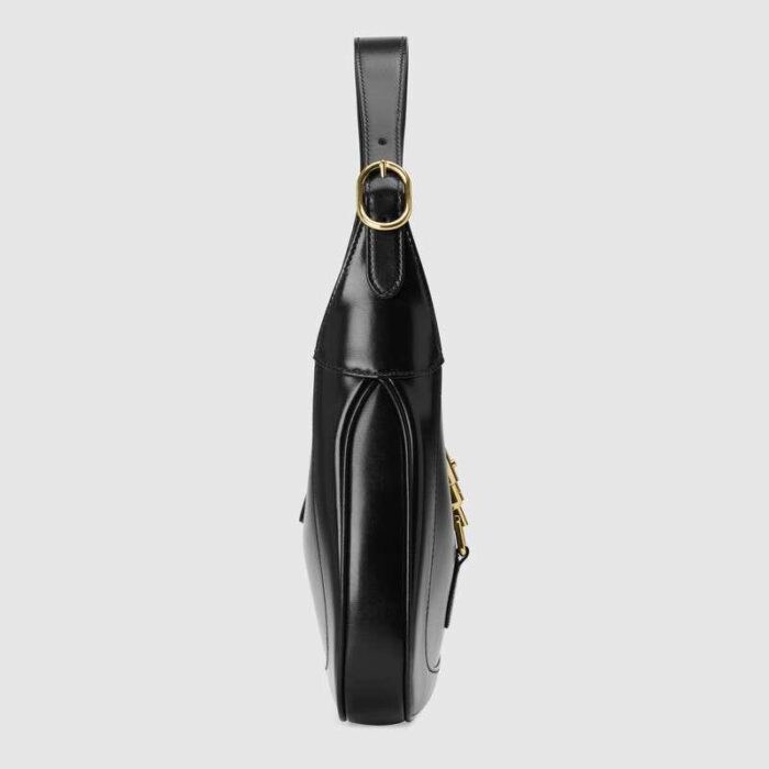 crafted in black leather with an additional detachable shoulder strap. The second shoulder strap can be fastened to the handbag with a buckle