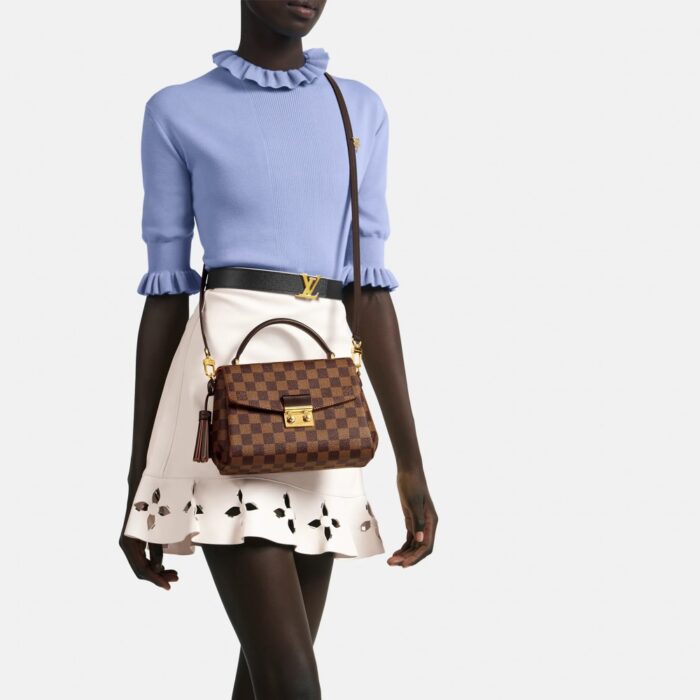 the Croisette in Damier Ebene canvas boasts sophisticated details (note the signature S-lock) and a casual-chic allure. The removable leather tassel adds a touch of fun. Sized to fit the essentials plus a long wallet
