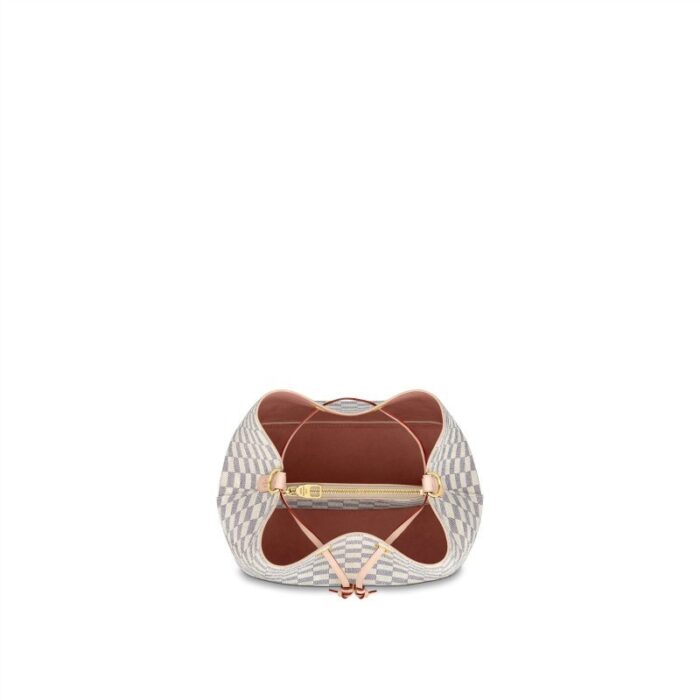 the NéoNoé bucket bag in Damier Azur canvas features a braided-leather top handle. The hand-painted edge-dyeing of the top-handle leather is a gauge of the House's commitment to craftsmanship. It can be hand-carried or worn over the shoulder and cross-body