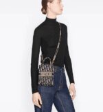 a play on the hallmark House pattern using reversed colors. Enhanced by the 'CHRISTIAN DIOR PARIS' signature on the front. The miniature bag will accommodate a phone as well as small daily essentials. Completed by an adjustable and removable embroidered shoulder strap